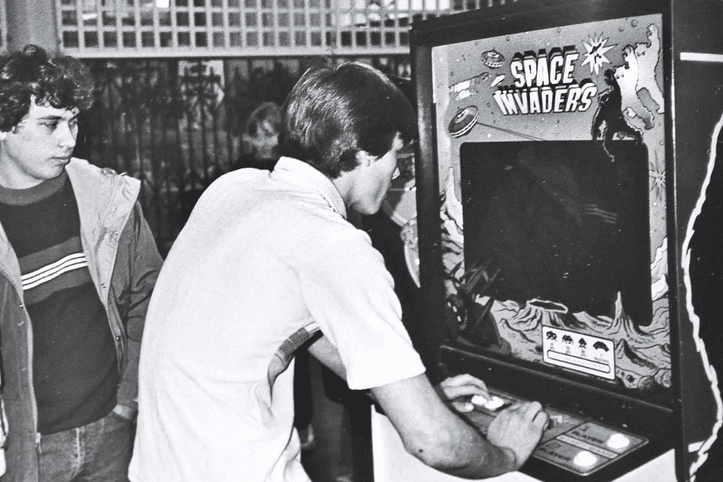 Image of a teenager playing the arcade game Space Invaders for a blog post covering milestones in the evolution of video games.